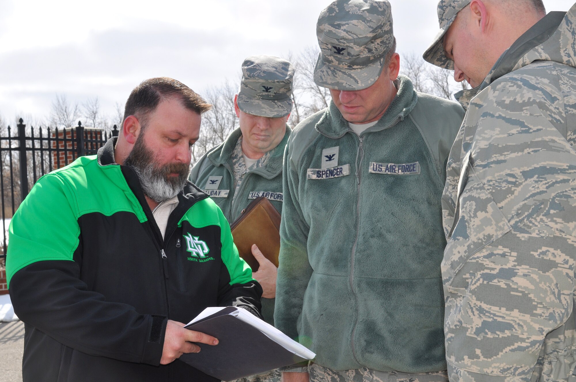 Jason Perkins, 319th Security Forces Squadron anti-terrorism program manager (left), reviews security upgrade information with 319th Air Base Wing leaders March 28, 2018, on Grand Forks Air Force Base, N.D. Recent unauthorized entries at other bases, put commanders on notice to conduct thorough reviews of installation security procedures and potential shortfalls in base protection. “I’m confident in our defenders and our security protocols, but there’s always room to improve. This provided me the opportunity to take a close look at how I can better equip base defenders to perform their vital mission,” said Spencer. (U.S. Air Force photo by Master Sgt. Amanda Callahan)