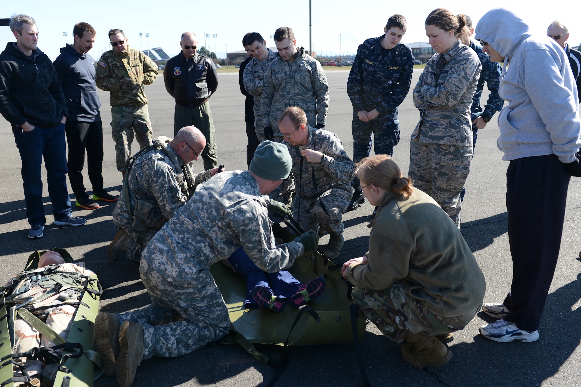 Washington National Guard crew chiefs assist Association of Military Osteopathic Physicians and Surgeons members to secure a simulated patient in a sked, March 10, 2018, at Joint Base Lewis-McChord, Wash. A sked is a tough plastic stretcher that can be used to move patients both on the ground and up to a hovering helicopter.  (U.S. Air Force photo by Airman 1st Class Sara Hoerichs)