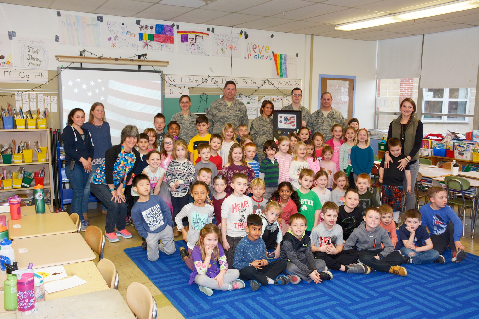 Members of the 157th Civil Engineer Squadron pose with students from the Garrison Elementary School in Dover, N.H. March 30, 2018.  Lt. Col. Eugene R. Mozzoni, 157th CES Commander, presented a flag and certificate to the students during a ceremony thanking the students for sending letters to the engineers while they were deployed to the Middle East. The flag was flown over the country of Kuwait during the last holiday season. (N.H. Air National Guard photo by Master Sgt. Thomas Johnson)