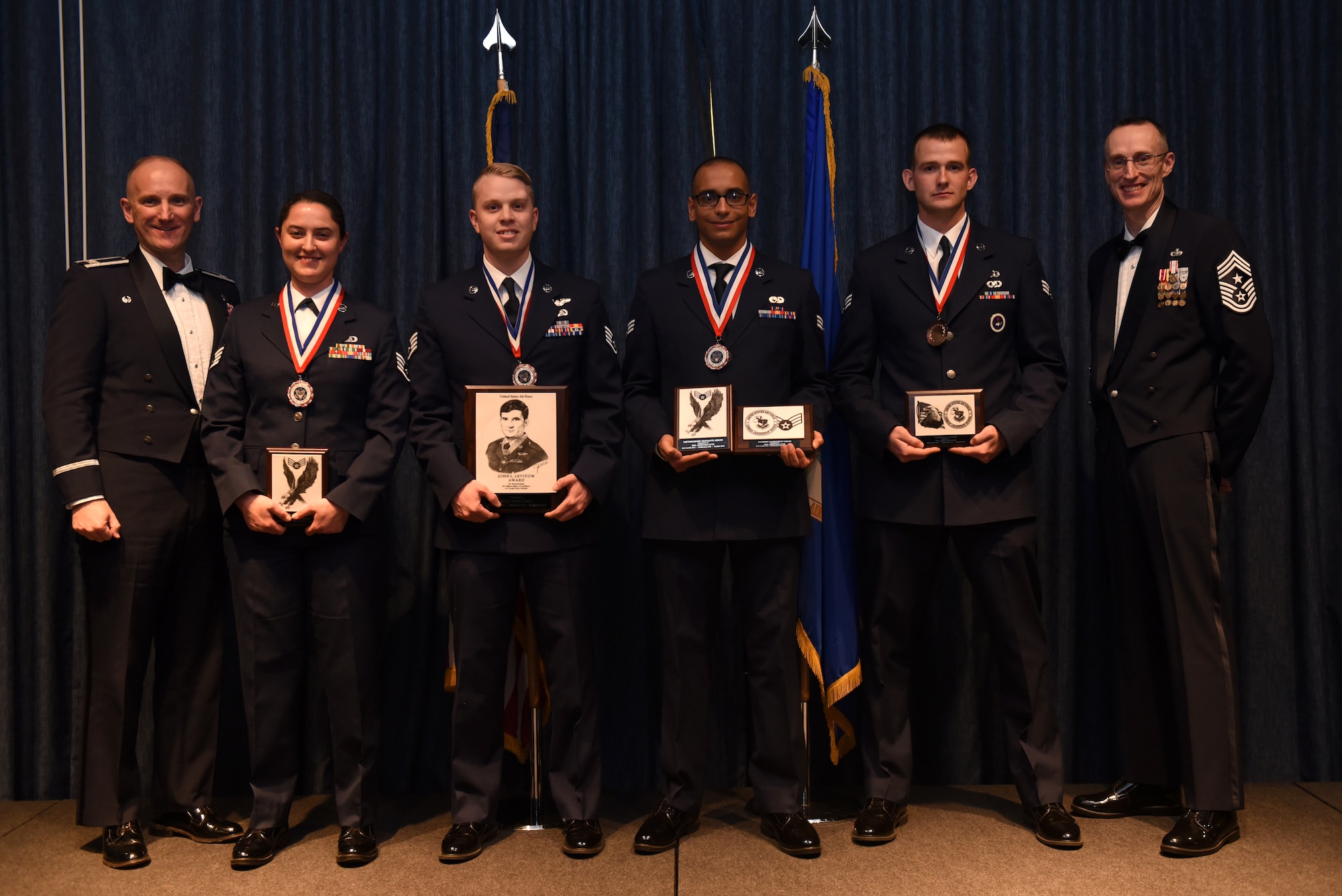 Airmen of Airman Leadership School Class 18 Charlie, who earned top honors, pose for a photo with Col. Ryan Samuelson, 92nd Air Refueling Wing commander, and Chief Master Sgt. Lee Mills, 92nd Air Refueling Wing command chief, March 29, 2018, at Fairchild Air Force Base, Washington. ALS is a five-week course that focuses on leadership abilities, profession of arms and effective communication in the workplace. (U.S. Air Force photo/Airman 1st Class Whitney Laine)