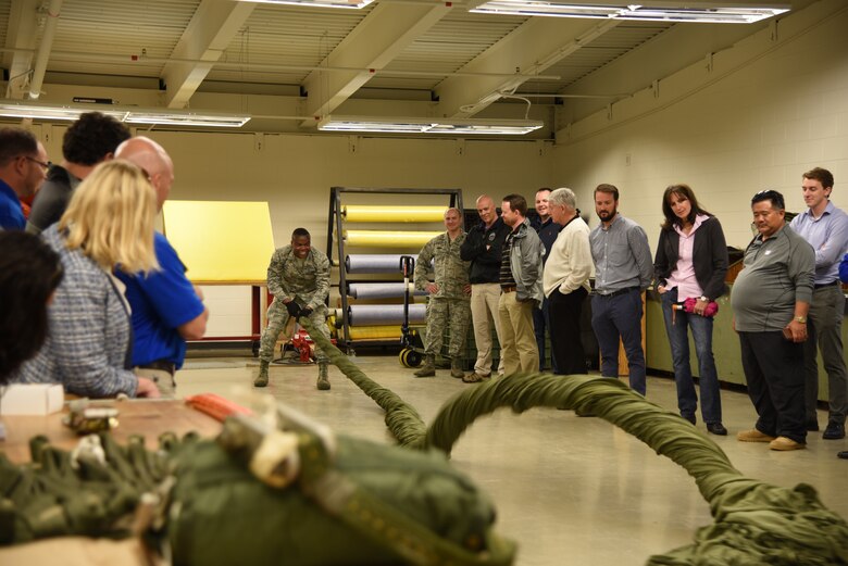 More than 35 business owners and area leaders from Tampa, Florida are given a demonstration by the 41st Aerial Port Squadron air transportation specialists on how a parachute is gathered up after a drop. The civic leaders toured the 403rd Wing at Keesler Air Force Base March 29, 2018. These tours promote community outreach to maintain and foster positive relationships between the local community and the military community. (U.S. Air Force photo by Master Sgt. Jessica Kendziorek)
