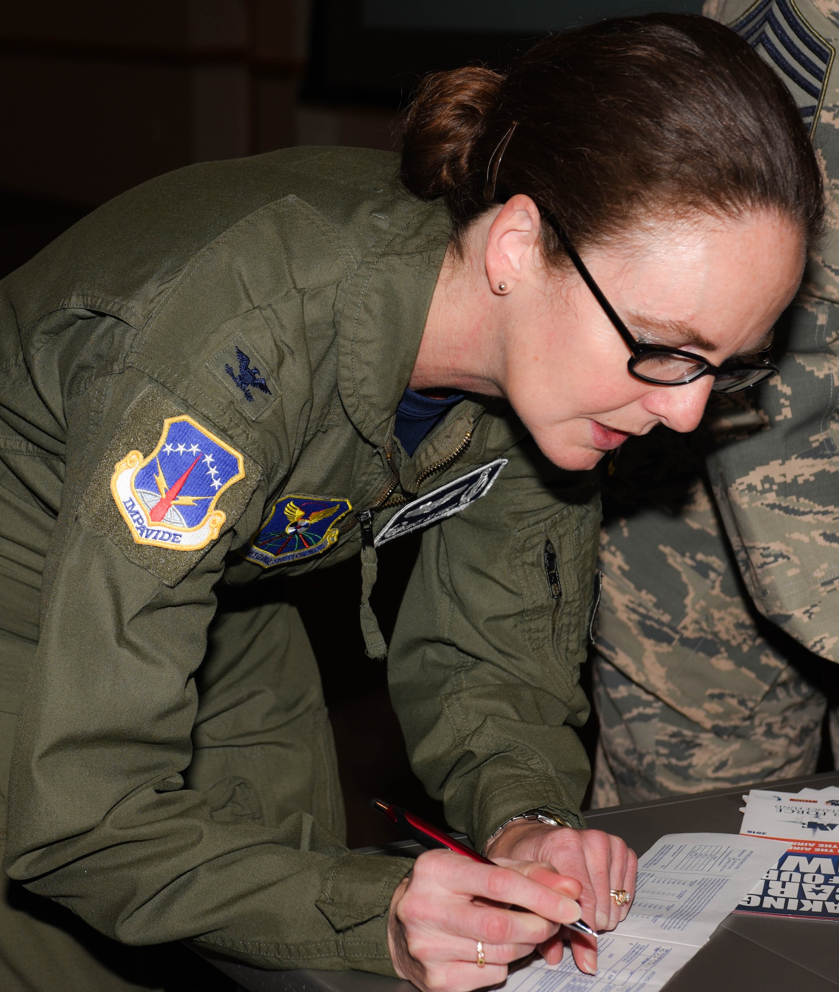 Col. Stacy Jo Huser, 90th Missile Wing commander, fills out a contribution slip during the Air Force Assistance Fund kickoff event at F.E. Warren Air Force Base, Wyo., March 30, 2018. The purpose of the event was to inform Airmen on base about the program and to receive the first contributions. AFAF helps Airmen with financial aid in instances such as, emergency situations, securing a retirement home for widows or widowers of Air Force members and more. (U.S. Air Force photo by Airman 1st Class Braydon Williams)