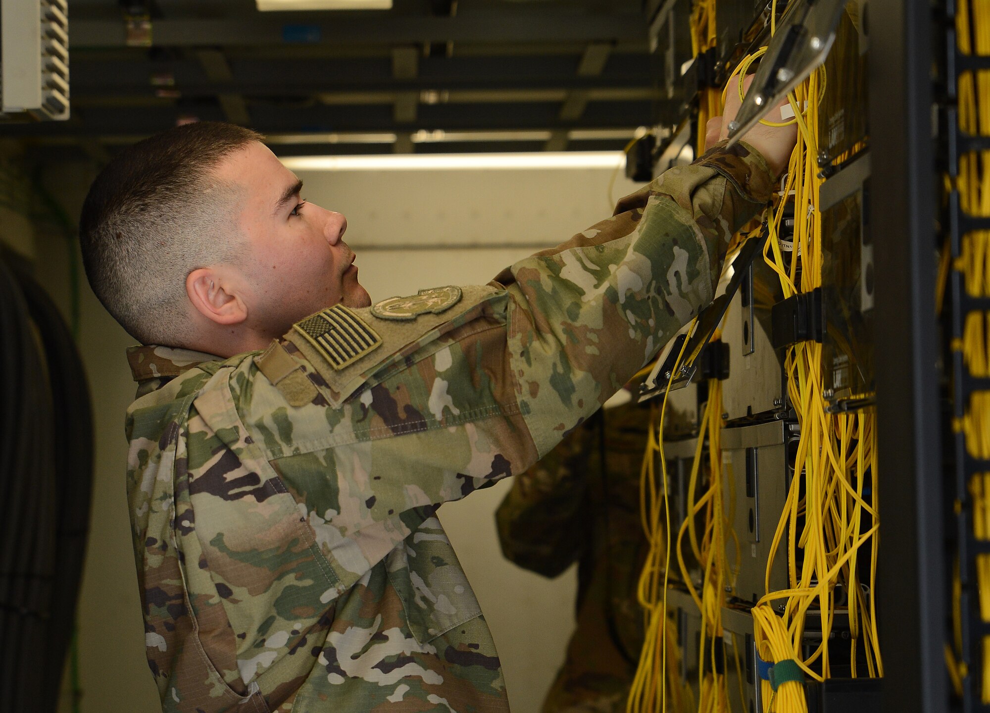 Staff Sgt. Brandon Hasegawa, 455th Expeditionary Communication Squadron cyber transport technician, checks the non-secure internet protocol router wires Mar. 22, 2018 at Bagram Airfield, Afghanistan.