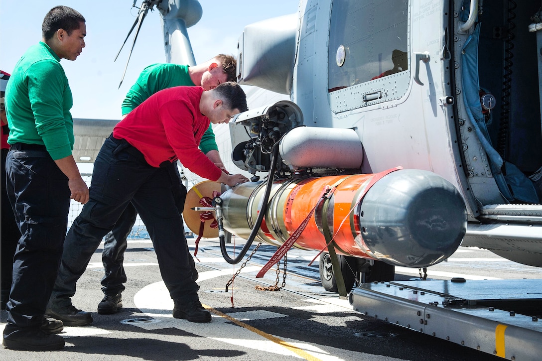 Sailors secure a Mark 46 lightweight torpedo to a helicopter