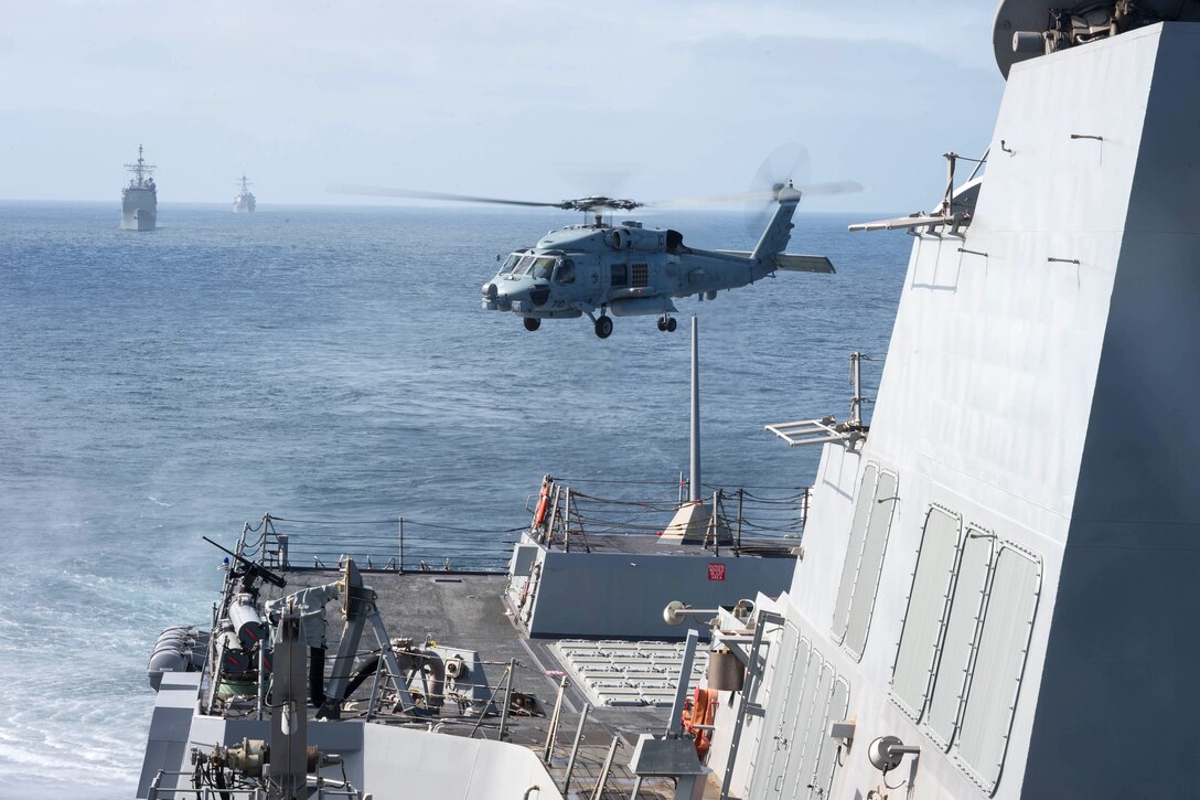 A helicopter takes off from the flight deck of USS Stockdale.