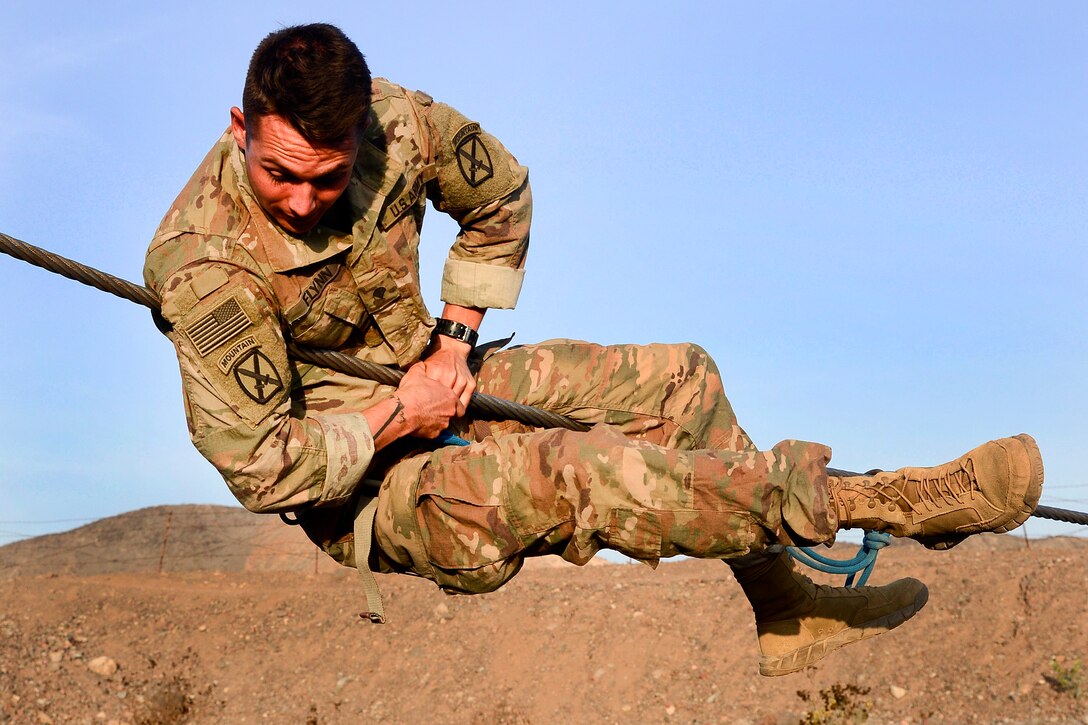 A Soldier practices recovering onto a single rope bridge.