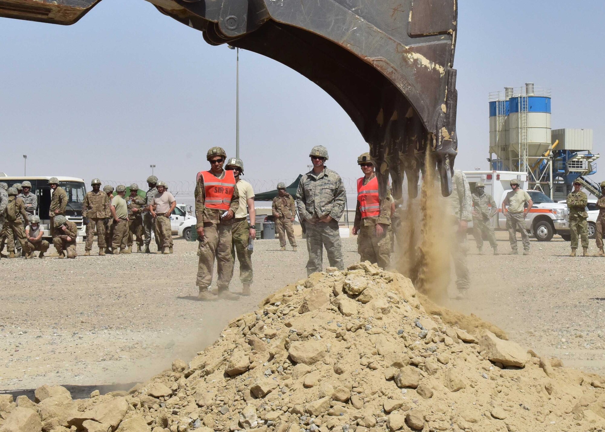 Airmen from the 386th Expeditionary Civil Engineer Squadron watch as an excavator removes debris from a crater during an exercise at an undisclosed location in Southwest Asia, April 20, 2018. The exercise focused on repairing the runway in a timely manner.