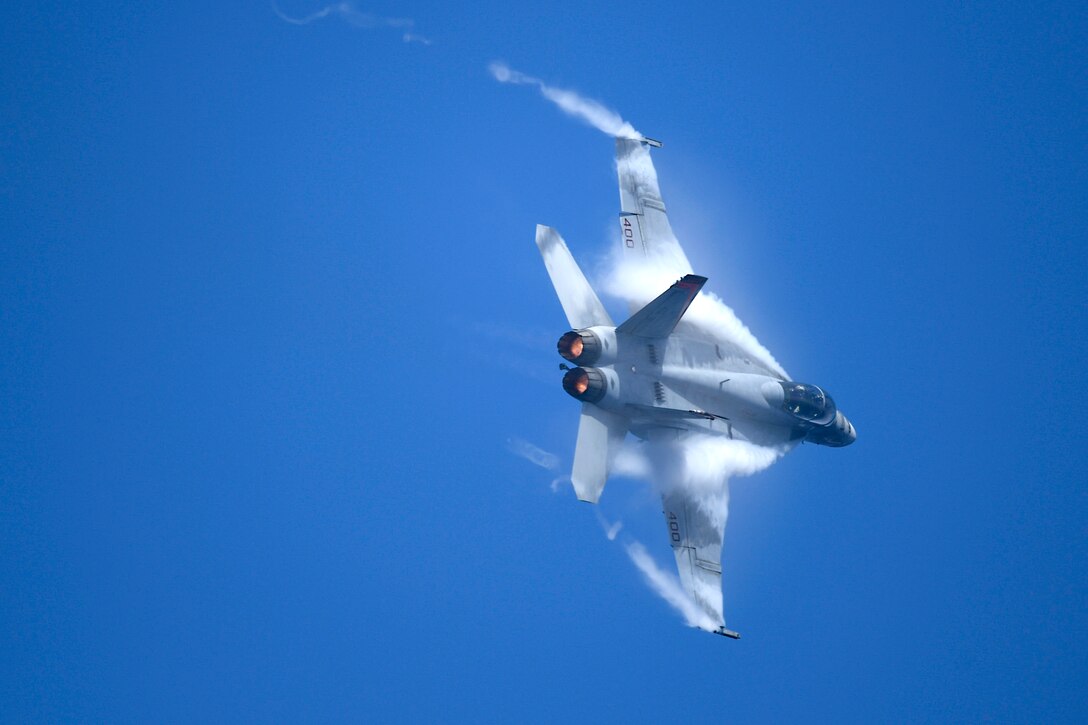 An aircraft flies with blue skies in the background.
