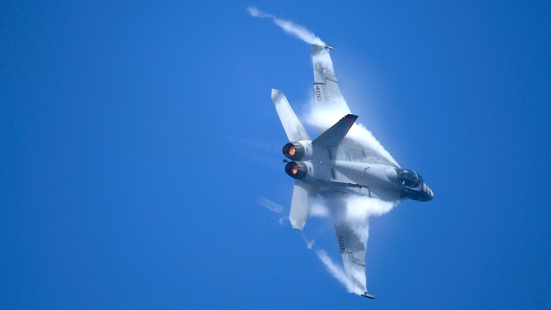 An aircraft flies with blue skies in the background.