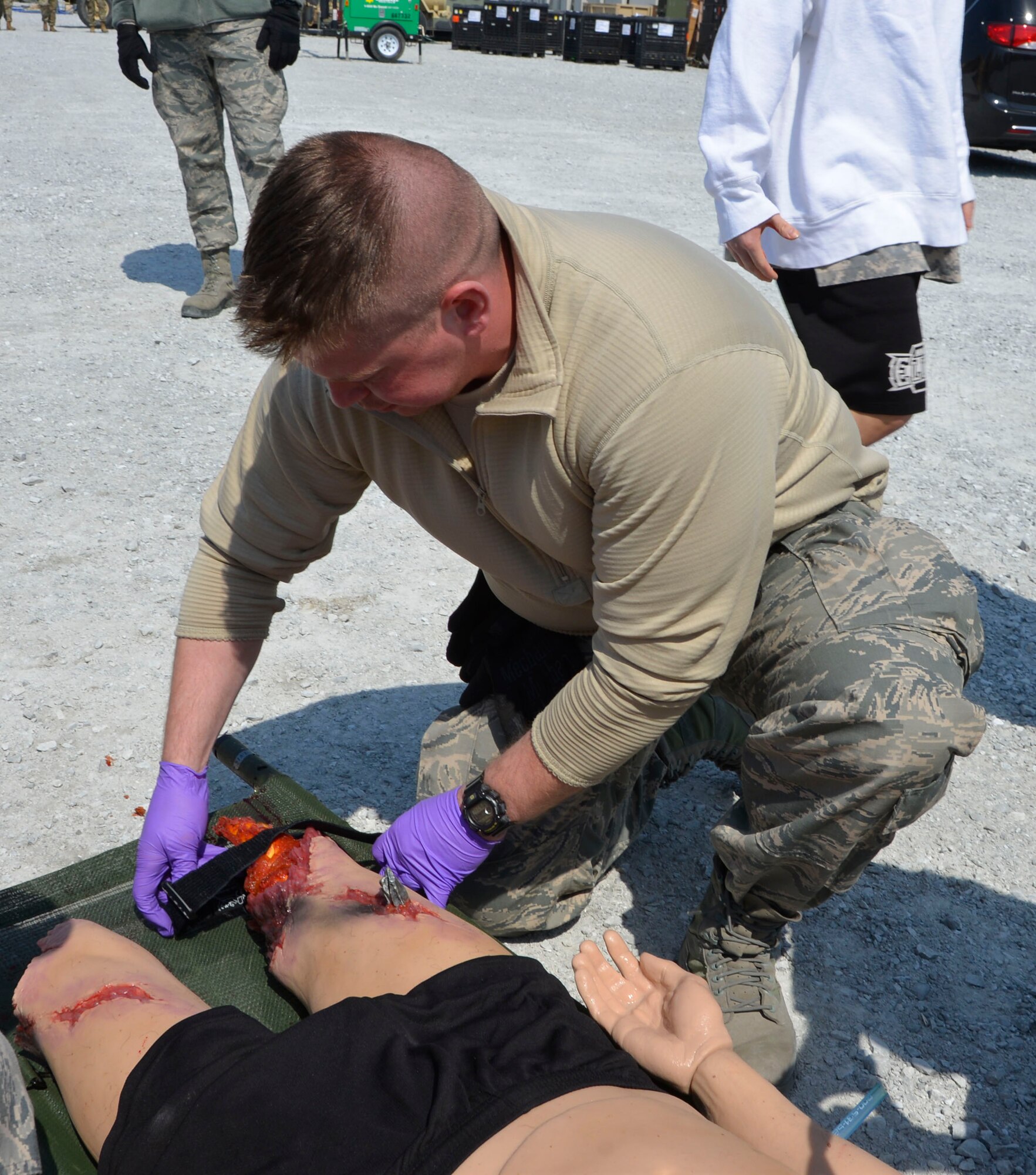 Senior Airman Glen Snyder, 81st Medical Group medic, Keesler Air Force Base, Miss., applies a tourniquet to a simulated  “resident” injured in the natural disaster tornado scenario during the Expeditionary Medical Support field confirmation exercise here April 18. The confirmation exercise is evaluating the tactics, techniques and procedures of EMEDS operations during a domestic U.S. contingency such as a natural disaster. (Air Force photo by Mary McHale)