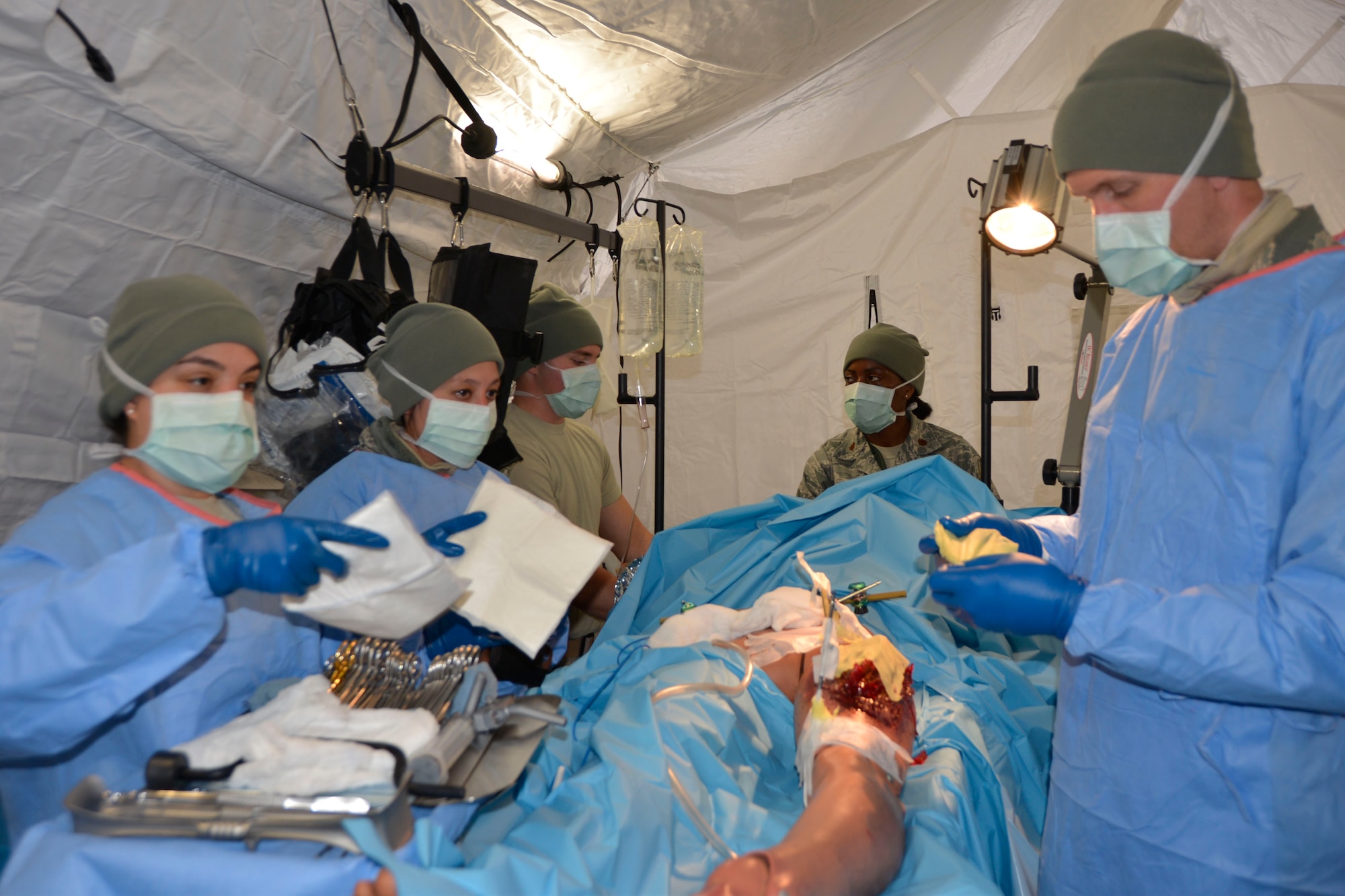 Staff Sgt. Luiza Pereira, surgical technician, 81st Medical Group, Keesler Air Force Base, Miss., hands a gauze dressing to Maj. (Dr.) T. David Tarity, 81st MDG, during an emergency surgery procedure on a natural disaster tornado scenario victim. The procedure was part of the ongoing Expeditionary Medical Support field confirmation exercise here April 18. The confirmation exercise is evaluating the tactics, techniques and procedures of EMEDS operations during a domestic U.S. contingency such as a natural disaster. (Air Force photo by Mary McHale)