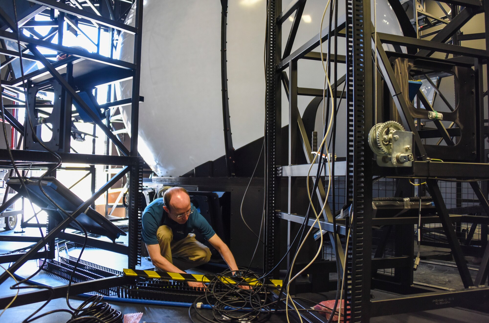 Paul Eger, a contracted Rockwell Collins F-35 simulator technician, runs wiring