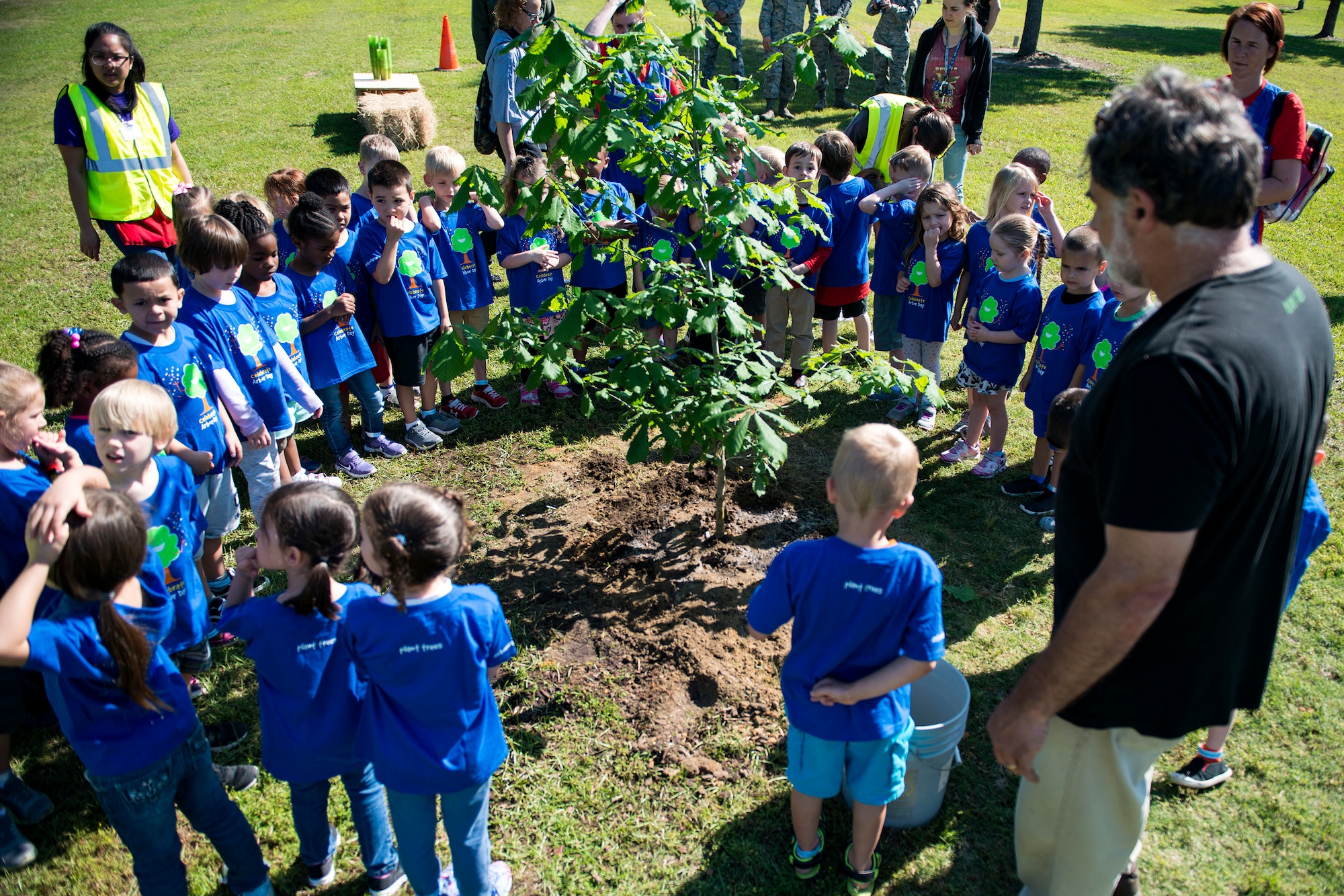Children from Moody’s child development center circle around a newly planted oak tree during Arbor Day, April 27, 2018, at Moody Air Force Base, Ga. Moody annually celebrates the holiday which encourages the benefits of planting trees. For 19 years the base has been a part of the Tree City USA Program by the National Arbor Day Foundation, to better prepare for the future of caring for their Airmen through improved ecological sustainability. (U.S. Air Force photo by Airman 1st Class Erick Requadt)