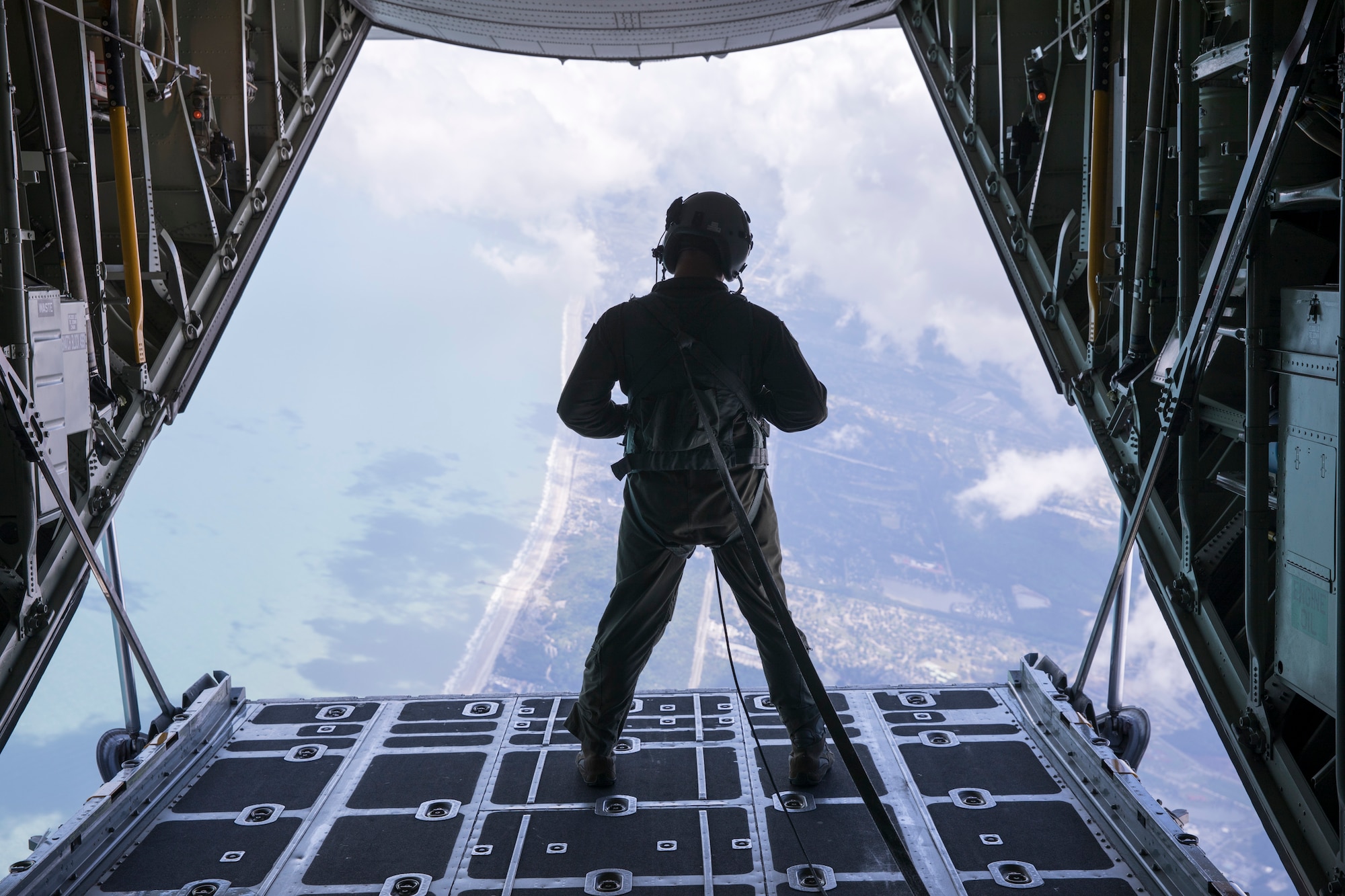 Master Sgt. Eric Schraeder, loadmaster with the 934th Airlift Wing, watches the descent of the SOCOM Para-Commandos after they depart the C-130 for their performance at the Wings Over Myrtle Beach Air Show April 27, 2018.  The SOCOM Para-Commandos are the only joint military demonstration team in the DoD; the aircrew from Minneapolis-St. Paul International Airport Air Reserve Station provided the jump team's airlift at the show. (Photo Courtesy Jason Lee, Sun News):