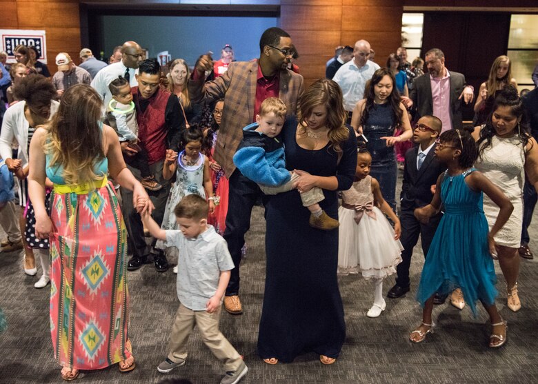 Parents dance with their children during the Father/Daughter and Mother/Son Dance at Joint Base Elmendorf-Richardson’s Arctic Warrior Events Center, April 27, 2018. The event was sponsored by the Family Advocacy Program, the Sexual Assault Prevention and Response Office, the 673d Medical Group, and the USO. Attendees had the chance to partake in Information booths, a build-your-own ice cream sundae bar and dancing.