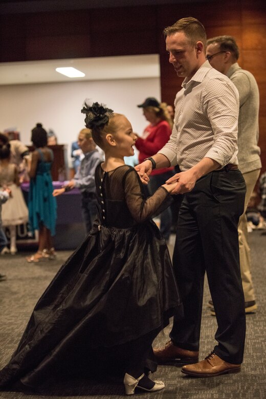 Air Force Staff Sgt. Anthony Kolo, a 673d Dental Squadron dental assistant, dances with his daughter Jherra, age 6, during the Father/Daughter and Mother/Son Dance at Joint Base Elmendorf-Richardson’s Arctic Warrior Events Center, April 27, 2018. The event was sponsored by the Family Advocacy Program, the Sexual Assault Prevention and Response Office, the 673d Medical Group, and the USO. Attendees had the chance to partake in Information booths, a build-your-own ice cream sundae bar and dancing.