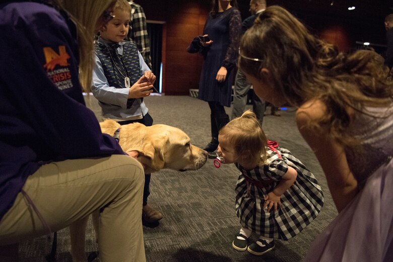 Amara, age 2, daughter of Air Force Staff Sgt. Seth Franks, 673d Surgical Squadron, greets Sawyer, a service dog trained to provide comfort during the Father/Daughter and Mother/Son Dance at Joint Base Elmendorf-Richardson’s Arctic Warrior Events Center, April 27, 2018. The event was sponsored by the Family Advocacy Program, the Sexual Assault Prevention and Response Office, the 673d Medical Group, and the USO. Attendees had the chance to partake in Information booths, a build-your-own ice cream sundae bar and dancing.