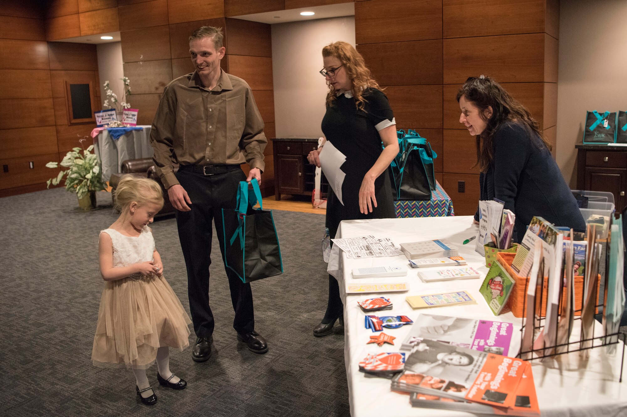 Parents receive gift bags and information provided by Family Advocacy during the Father/Daughter and Mother/Son Dance at Joint Base Elmendorf-Richardson’s Arctic Warrior Events Center, April 27, 2018. The event was sponsored by the Family Advocacy Program, the Sexual Assault Prevention and Response Office, the 673d Medical Group, and the USO. Attendees had the chance to partake in Information booths, a build-your-own ice cream sundae bar and dancing.