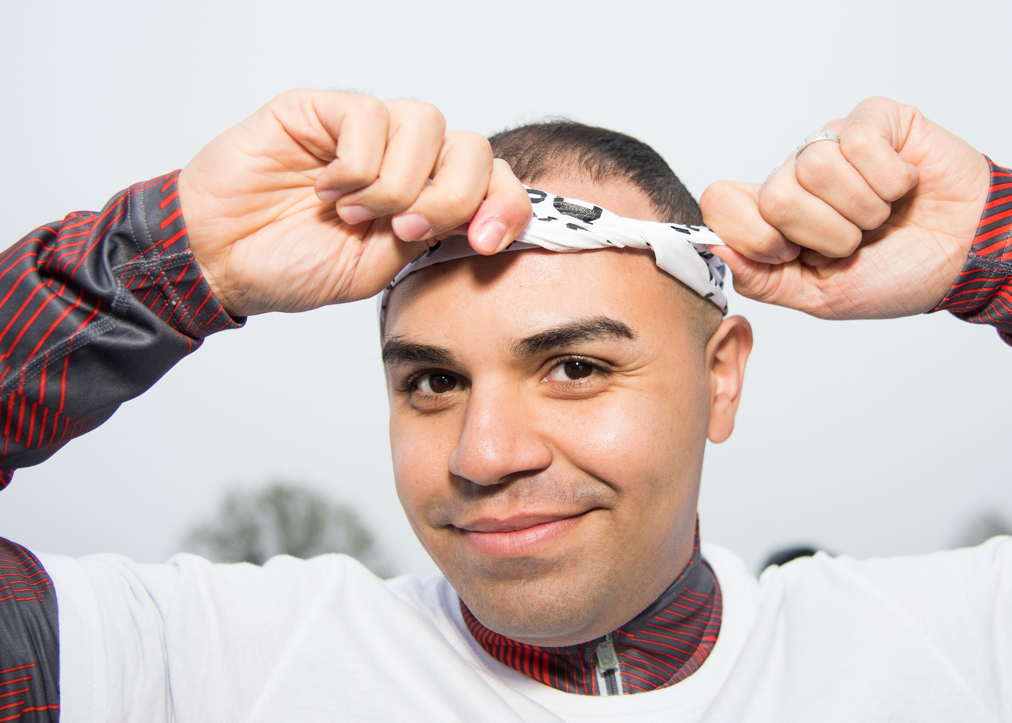 Master Sgt. Alexander Collazo, 436th Communications Squadron first sergeant, ties a scarf around his head before the Sexual Assault Awareness Month Color Run April 25, 2018, at Dover Air Force Base, Del. Although the colored powder is not harmful, runners were provided scarves to prevent them from inhaling the powder during the run. (U.S. Air Force photo by Mauricio Campino)