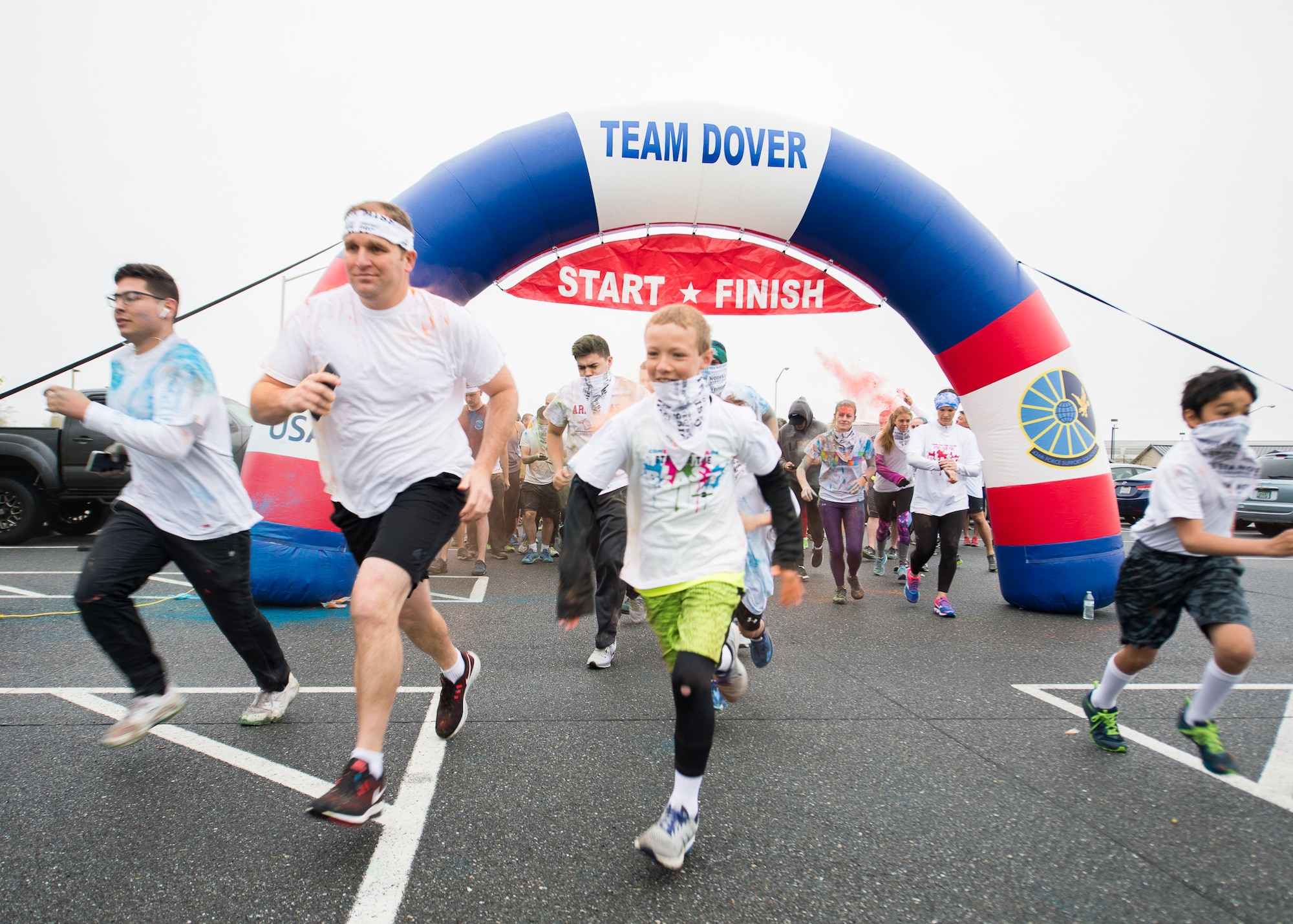 Participants of the Sexual Assault Awareness Month Color Run leave the start and finish line April 25, 2018, at Dover Air Force Base, Del. The 5k course started and finished at the base theater and ran along the perimeter fence. (U.S. Air Force photo by Mauricio Campino)