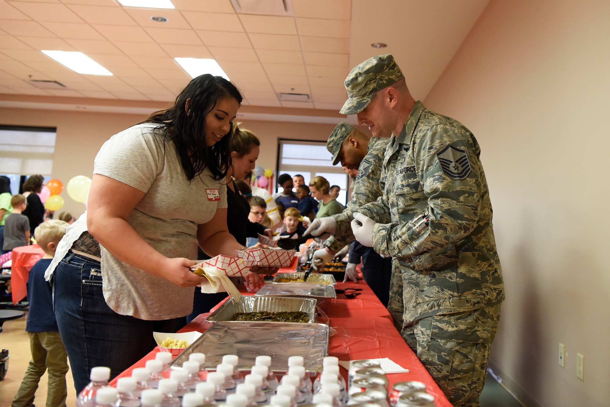 Members of the 436th Medical Group serve dinner to the families of deployed Airmen at the Deployed Families Dinner April 19, 2018, at Dover Air Force Base, Del. The dinner was catered by Chick-fil-A and Mission BBQ. (U.S. Air Force photo by Airman 1st Class Zoe M. Wockenfuss)