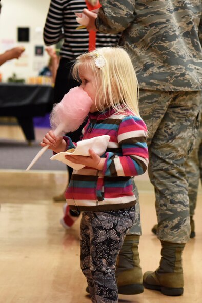 Eliana Swaim, daughter of Capt. Jessica Swaim, 436th Medical Support Squadron logistics flight commander, enjoys cotton candy during the Deployed Families Dinner April 19, 2018, at Dover Air Force Base, Del. The carnival-themed event featured several treats, including cotton-candy, snow cones and pop-corn. (U.S. Air Force photo by Airman 1st Class Zoe M. Wockenfuss)