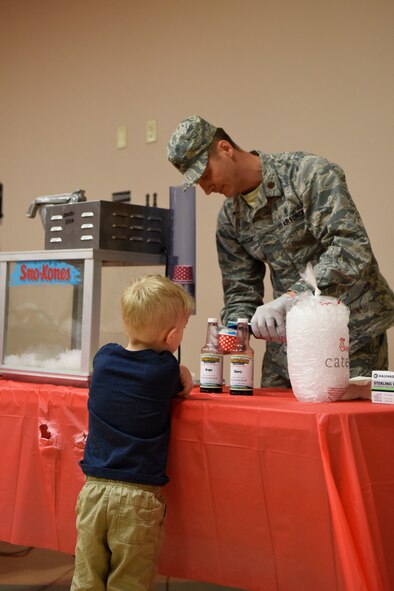 Michael Waszak, son of Capt. Christopher Waszak 9th Airlift Squadron C-5M Super Galaxy pilot, prepares a snow cone during the Deployed Families Dinner April, 19 2018, at Dover Air Force base, Del. The dinner was co-hosted by the 436th Medical Group and the Airman and Family Readiness Center. (U.S. Air Force photo by Airman 1st Class Zoe M. Wockenfuss)