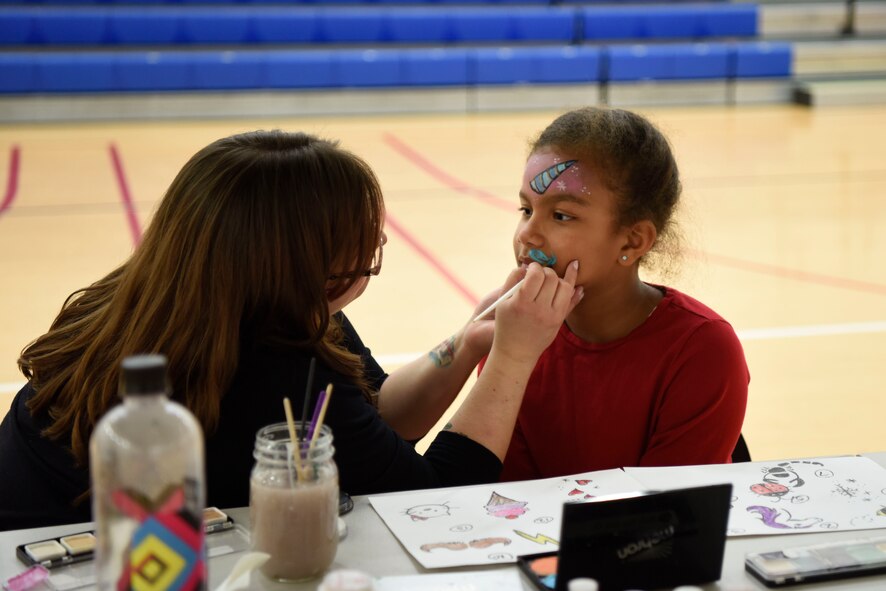 Aarilyn Brown, daughter of 1st Sgt. Sharry Barnshaw, 3rd Airlift Squadron first sergeant, gets her face painted by a volunteer during the Deployed Families Dinner April 19, 2018, at Dover Air Force Base, Del. In addition to face painting, corn-hole, a photo booth and two bounce houses were provided for the families. (U.S. Air Force photo by Airman 1st Class Zoe M. Wockenfuss)