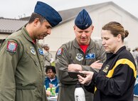 From right, Lt. Col. Laura Wood, Joint Personal Effects Depot officer in charge, shows photos of her team’s performance during the Wingman Day Amazing Race to Col. Larry Nance, 436th Operations Group commander, and Chief Master Sgt. Eduardo Pena, 436th OG superintendent, April 27, 2018, on Dover Air Force Base, Del. Each team had to take a selfie at each of the 10 locations upon completing an Amazing Race challenge. (U.S. Air Force photo by Roland Balik)