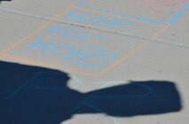 An Airman with the 432nd Wing/432nd Air Expeditionary Wing participates in a Chalk the Walk event April 20, 2018, at Creech Air Force Base, Nev. Airmen worked together to create a “Hop for Hope” hopscotch game for members to engage in on their walk to the base dining facility. (U.S. Air Force photo by Airman 1st Class Haley Stevens)