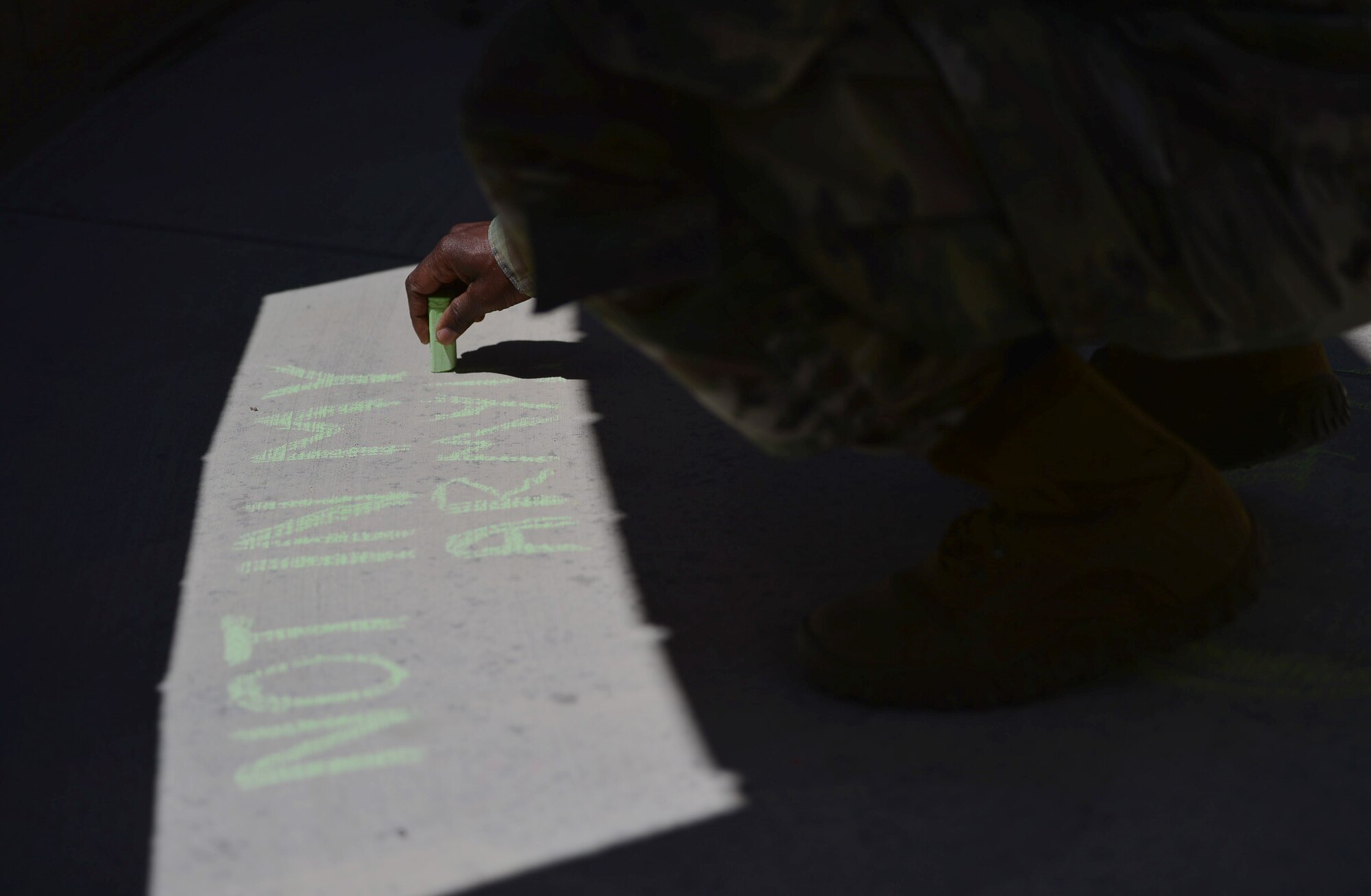 A U.S. Army soldier shows his support during a Chalk the Walk event April 20, 2018, at Creech Air Force Base, Nev. These events focus on supporting victims of sexual assault and helping them understand the resources that are available for them. (U.S. Air Force photo by Airman 1st Class Haley Stevens)