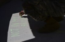 A U.S. Army soldier shows his support during a Chalk the Walk event April 20, 2018, at Creech Air Force Base, Nev. These events focus on supporting victims of sexual assault and helping them understand the resources that are available for them. (U.S. Air Force photo by Airman 1st Class Haley Stevens)