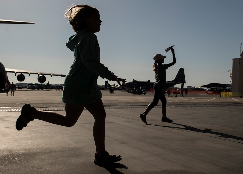 A child chases down a paper airplane during a paper-plane-throwing competition at the Air and Space Expo at Joint Base Charleston, S.C.