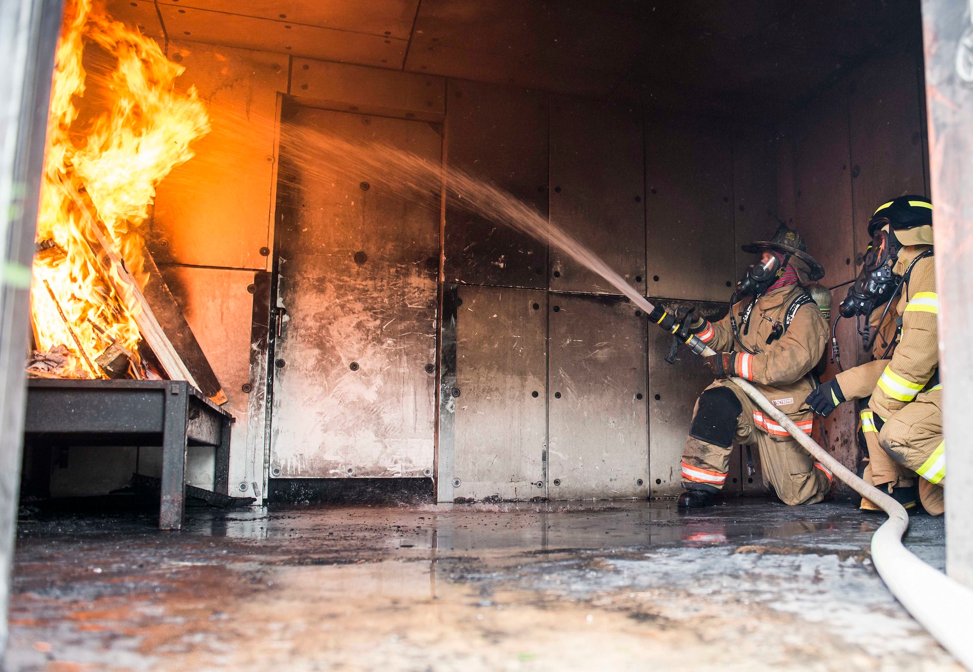 U.S. Air Force and Republic of Korea Air Force firefighters extinguish a training building fire during exercise Silver Flag April 24, 2018, at Northwest Field, Guam. The weeklong exercise is designed to build partnerships and promote interoperability through the exchange of civil engineer-related information. (U.S. Air Force by Airman 1st Class Christopher Quail)