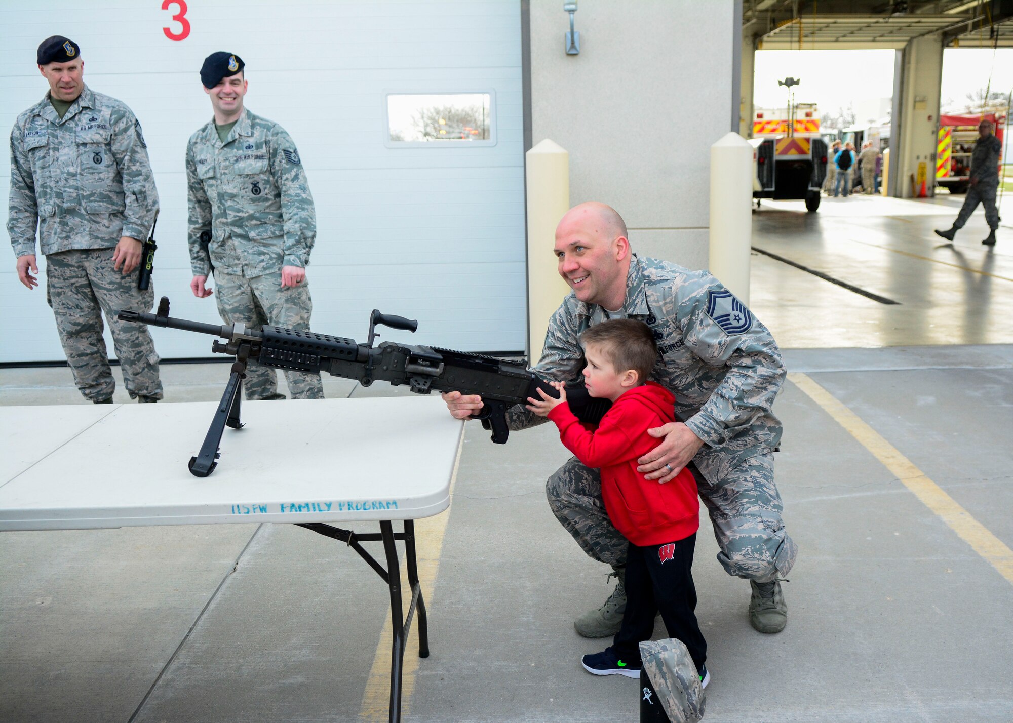 Jason Kasten, a host aviation resource manager with the 115th Operations Support Squadron, and his son Jordy Kasten hold an M249 light machine gun during National Take Our Daughters and Sons to Work Day April 26, 2018. 
(U.S. Air National Guard photo by Cameron R. Lewis)