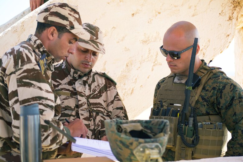U.S. Reserve Marine Staff Sgt. Philip J. Michell, a fire support Marine with 4th Air Naval Gunfire Liaison Company, Force Headquarters Group, Marine Forces Reserve, discusses operations with members of Moroccan Armed Forces during Exercise African Lion 2018, in Tan Tan, Morocco, April 23, 2018. African Lion is an annual, multinational, joint-force exercise improving interoperability between participating nations. (U.S. Marine Corps photo by Lance Cpl. Tessa D. Watts)