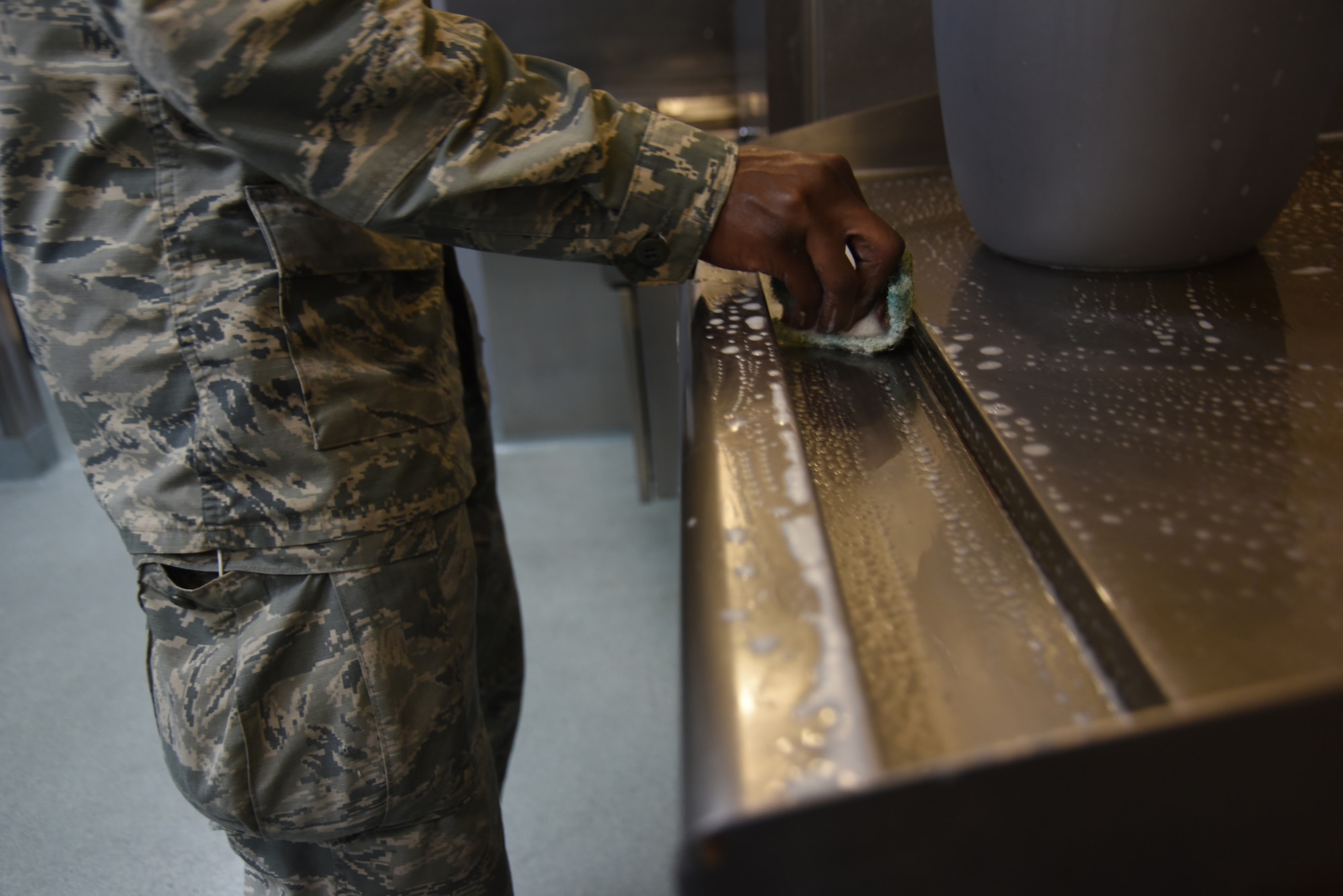 Airman cleaning stove.