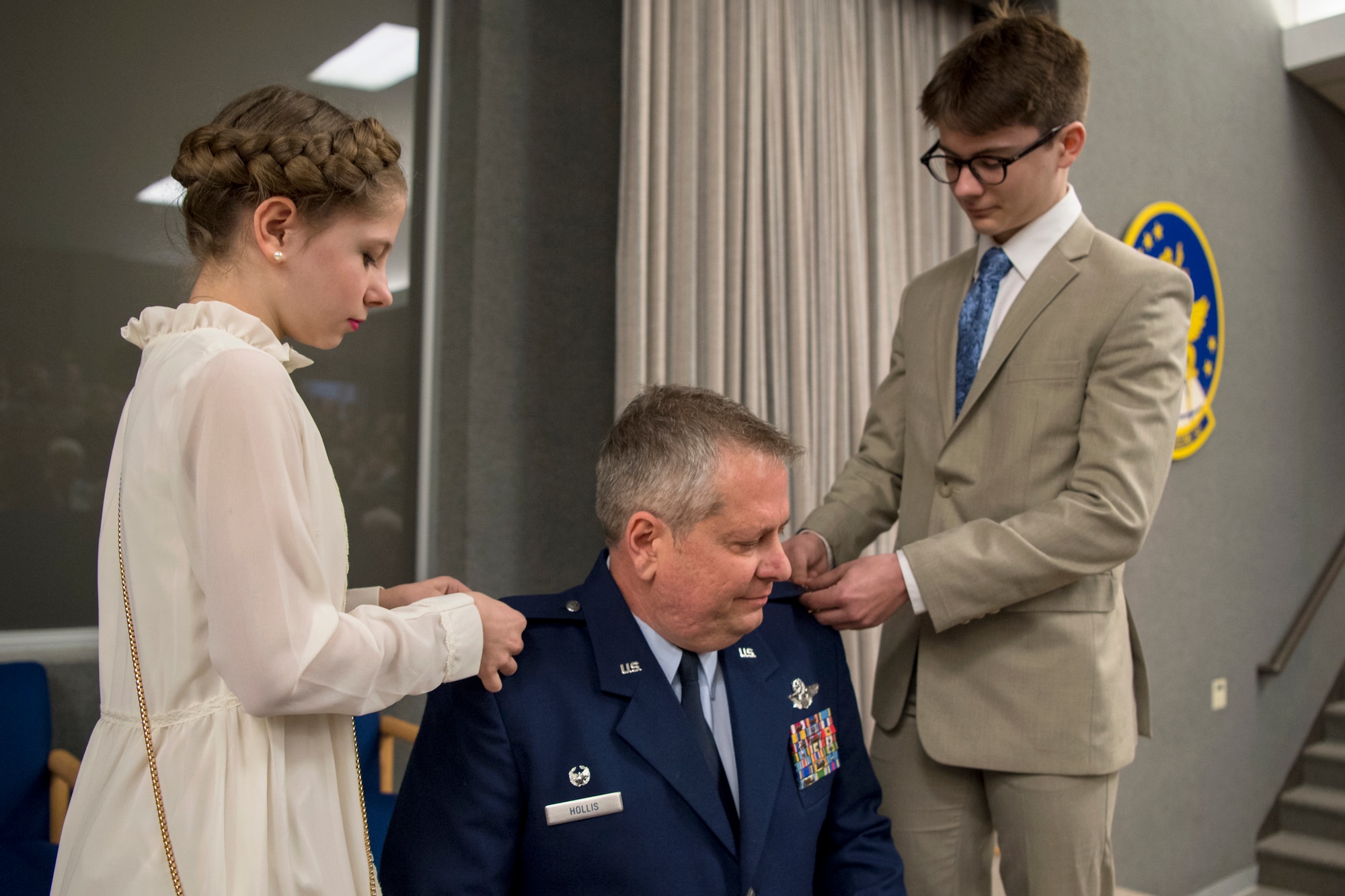 In the center, Col. Brian Hollis, 434th Operational Support Squadron commander, has his children, Isabel and Isaac, add new eagle rank insignias on his service coat during a pin-on ceremony at Grissom Air Reserve Base, Ind., April 7, 2018. Before taking command of the 434th OSS, Hollis held numerous jobs within the 434th ARW, including tanker scheduler, nuclear plans officer, assistant chief pilot tactics officer, chief of mission development, chief of plans and director of operations. (U.S. Air Force photo/Tech. Sgt. Benjamin Mota)