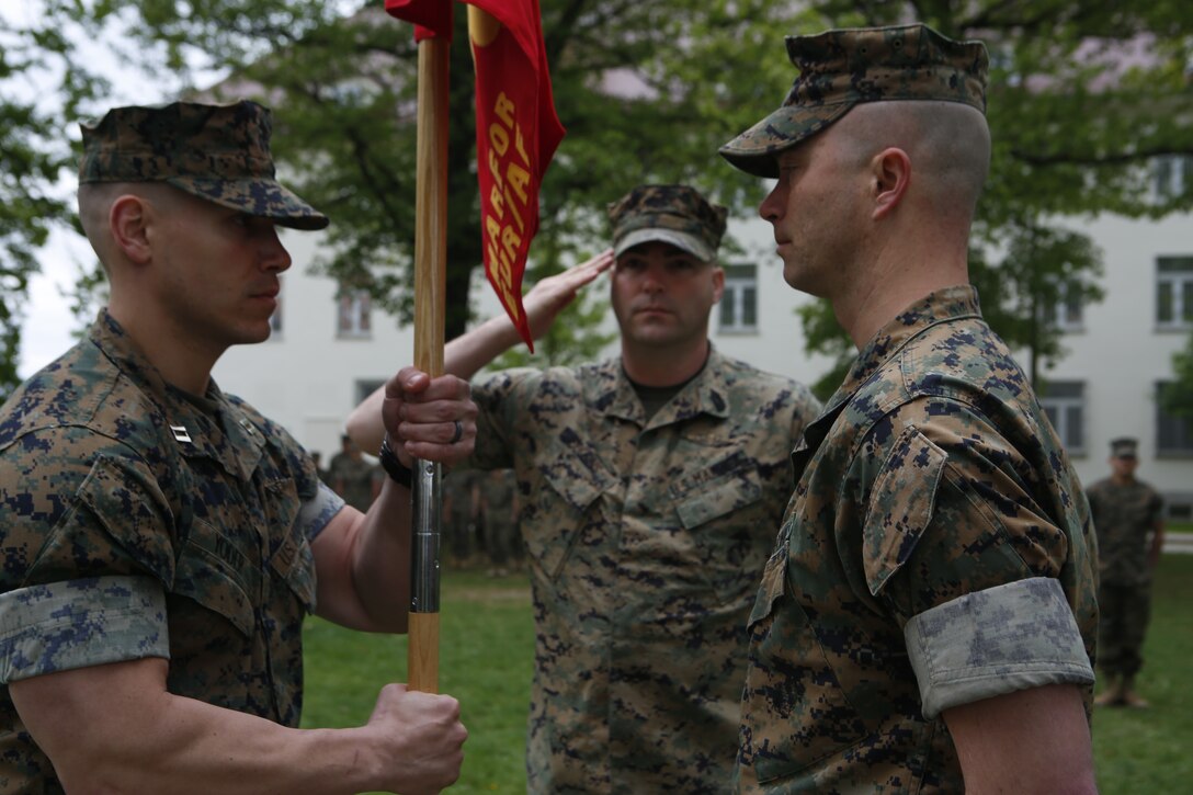 U.S. Marine Capt. Brett Yoder, on coming commander of Headquarters Company, Marine Forces Europe and Africa, receives the unit colors from Capt. Chronis, off going, during a MARFOREURAF change of command ceremony on Panzer Kaserne, Stuttgart, Germany, May 1, 2018. The passing of the unit guidon traditionally symbolizes the transfer of responsibility, authority, and accountability for the command by the outgoing commander to the incoming commander. (U.S. Marine Corps photo by Sgt. Averi Coppa/Released)