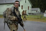 Oregon National Guard Staff Sgt. Jon Paul Hanson, a sniper with the 2nd Battalion, 162nd Infantry Regiment, enters the 'Leschi Town' training area during an early morning advancement during Exercise Cougar Rage, April 28, 2018, at Joint Base Lewis-McChord, Washington. U.S. and Canadian soldiers took part in four-days of joint training to enhance operational readiness, April 26-29.