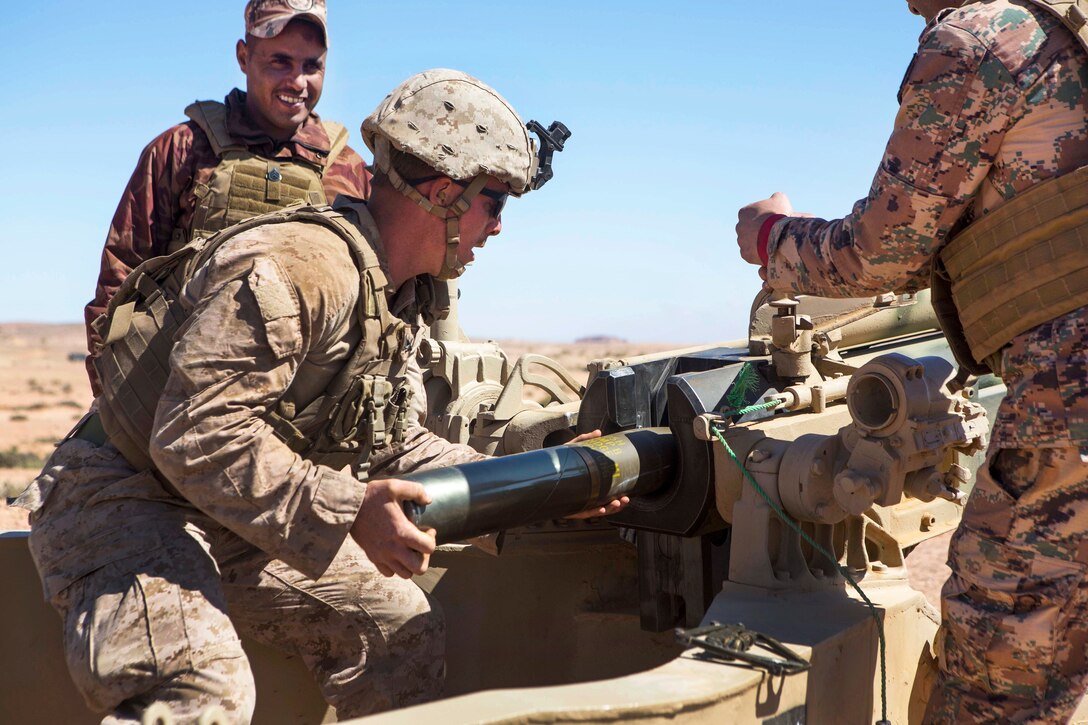 A Marine loads a round into a M137A1 105 mm howitzer.