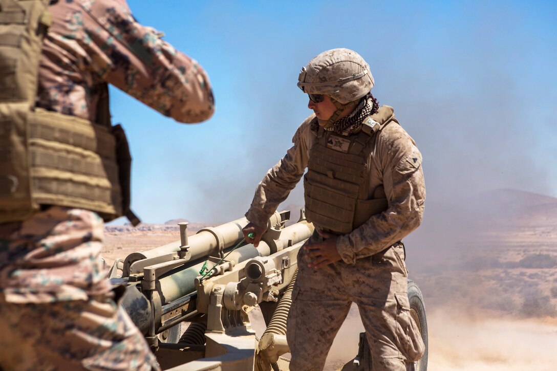 A Marine fires a M137A1, 105 mm howitzer.