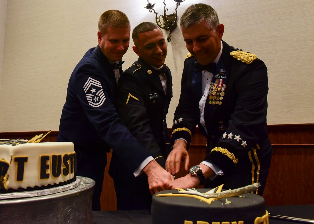 From left: U.S. Air Force Chief Master Sgt. Kennon D. Arnold, 633rd Air Base Wing command chief master sergeant, U.S. Army Pvt. Jesus Escudero, Delta Company, 222nd Aviation Regiment, 1st Aviation Battalion, 128th Aviation Brigade aircraft powerplant repairer, and U.S. Army General Stephen J. Townsend, Training and Doctrine Command commanding general, cut a cake at the Fort Eustis 100th Anniversary Gala in Newport News, Virginia, April 28, 2018. In keeping with Army tradition, the most senior and junior service members cut a cake together. (U.S. Air Force photo by Airman 1st Class Monica Roybal)