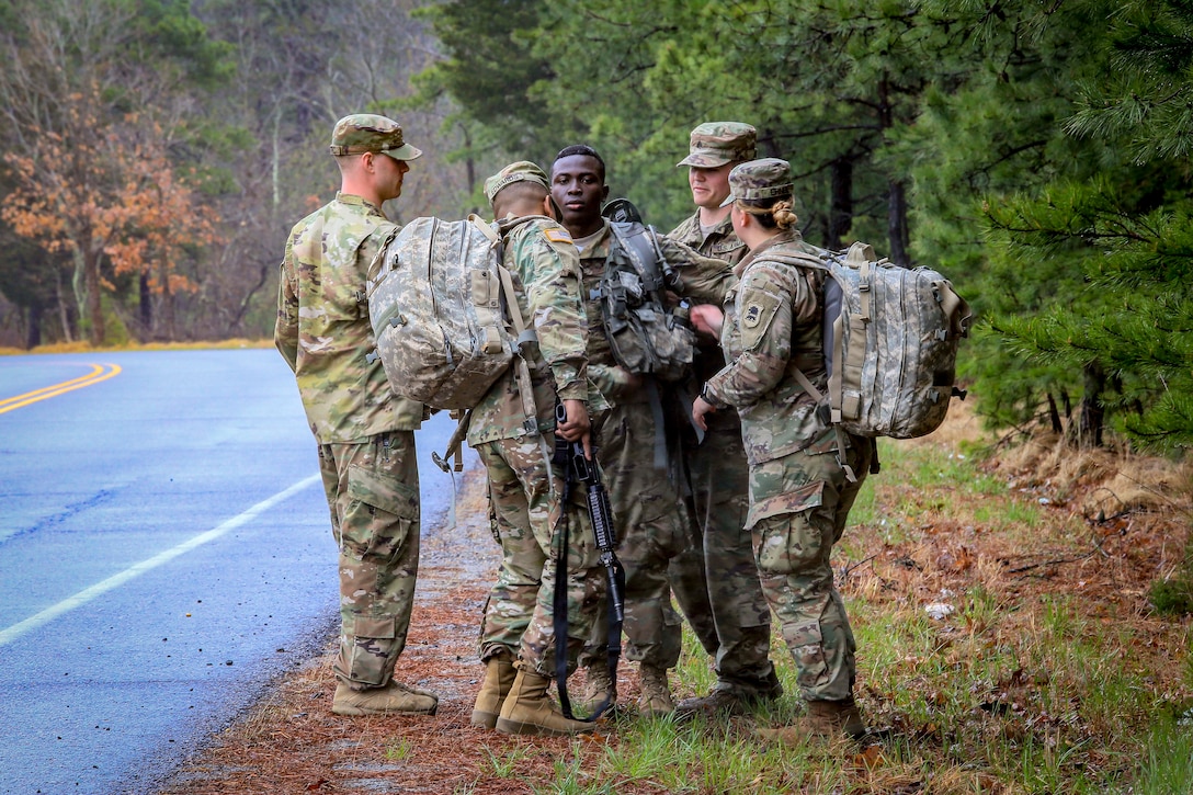 Army medics assist a soldier after he completed a 12-mile ruck march.