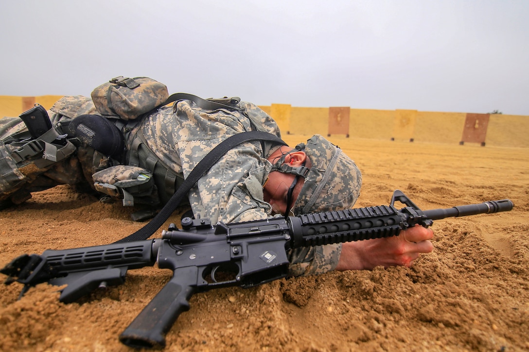 A soldier low crawls during the stress shoot.