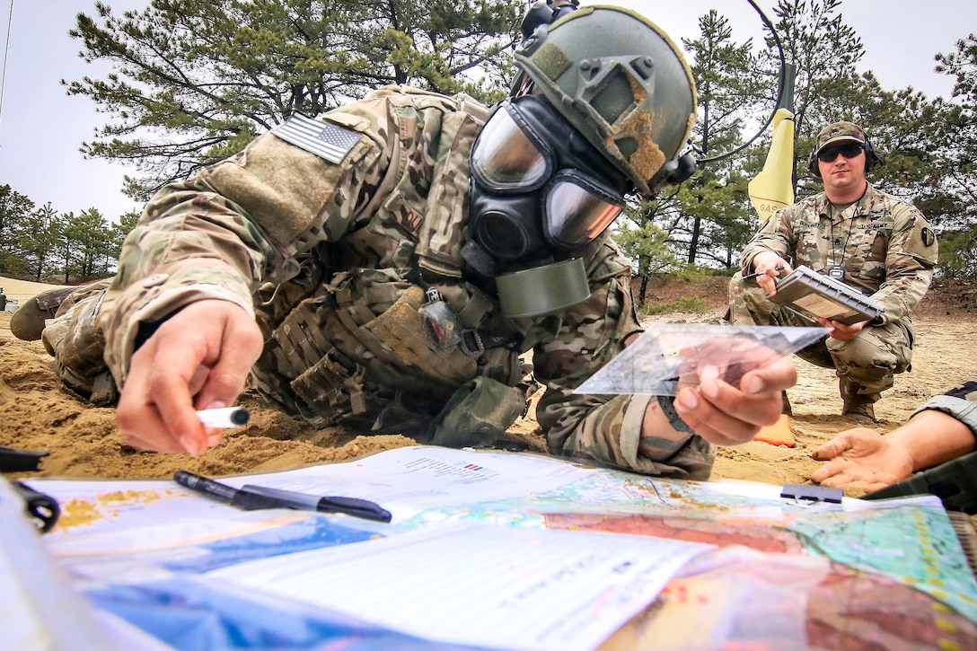 An airman goes over map coordinates and medical documents.