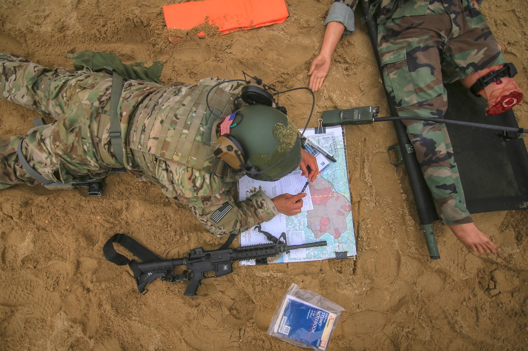 An airman finalizes his map coordinates before transporting a mock casualty.