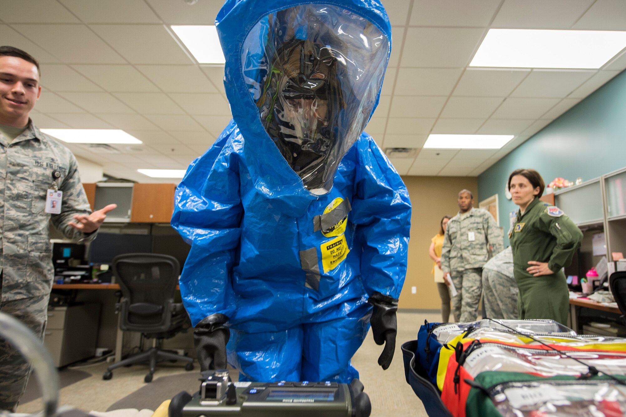Col. Jennifer Short, center, 23 Wing commander, inspects a specimen while wearing a Level A suit, April 30, 2018, at Moody Air Force Base, Ga. Short toured the 23d Medical Group (MDG) to gain a better understanding of their overall mission, capabilities, and comprehensive duties, and was able to experience the day-to-day operations of the various units within the 23d MDG, ranging from bioenvironmental to ambulatory care. (U.S. Air Force photo by Airman 1st Class Eugene Oliver)