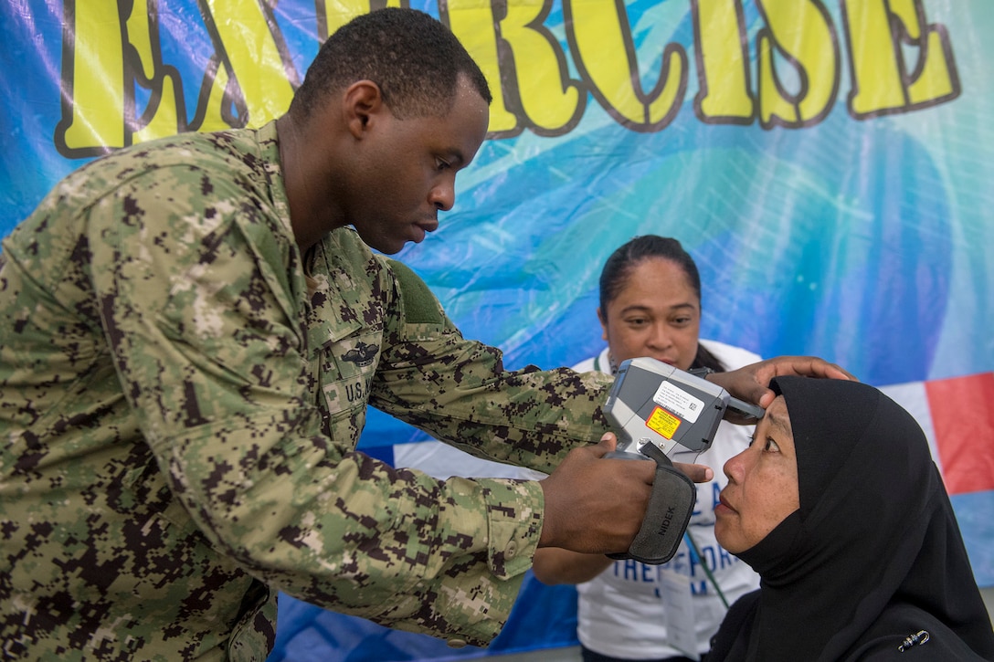 A Navy sailor conducts an eye examination during a Pacific Partnership 18.