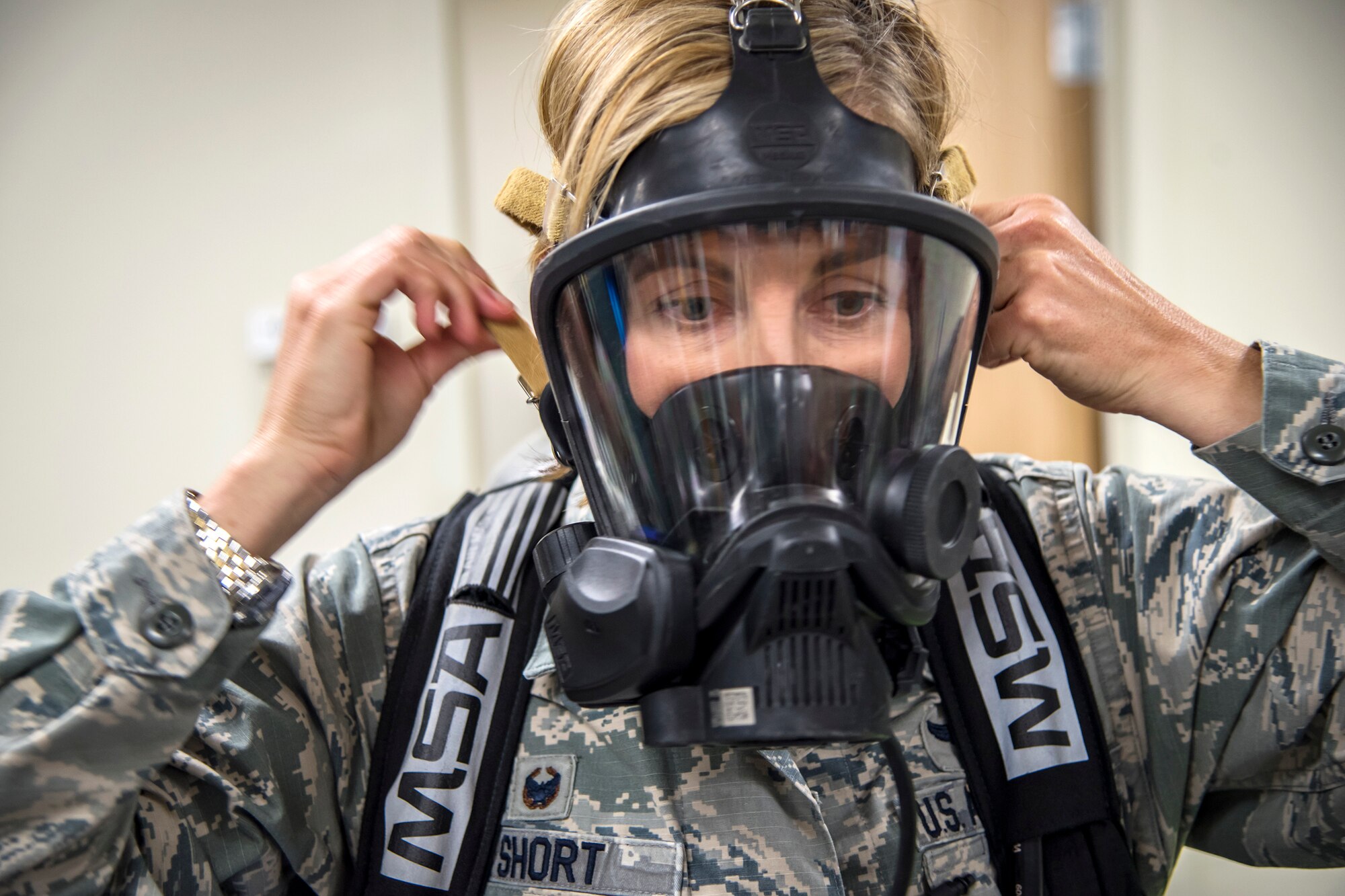 Col. Jennifer Short, 23d Wing commander, tightens a gas mask, April 30, 2018, at Moody Air Force Base, Ga. Short toured the 23d Medical Group to gain a better understanding of their overall mission, capabilities, and comprehensive duties, and was able to experience the day-to-day operations of the various units within the 23d MDG, ranging from bioenvironmental to ambulatory care. (U.S. Air Force photo by Airman 1st Class Eugene Oliver)